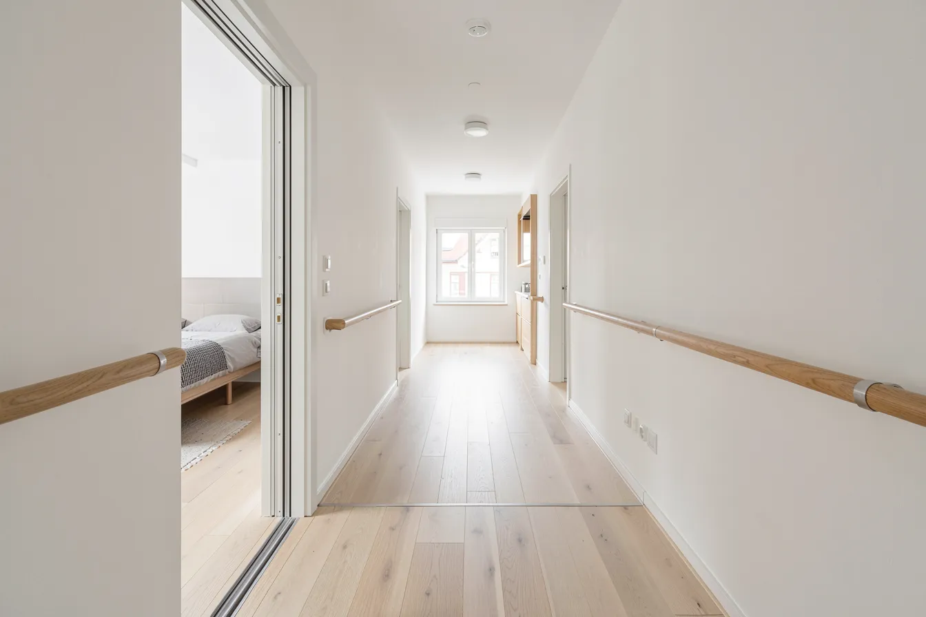 Breiter barrierefreier Flur mit Haltegriffen und schwellenlosem Übergang ins Schlafzimmer