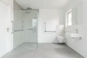 Modernes barrierefreies Badezimmer mit bodengleicher Dusche, Haltegriffen und unterfahrbarem Waschtisch