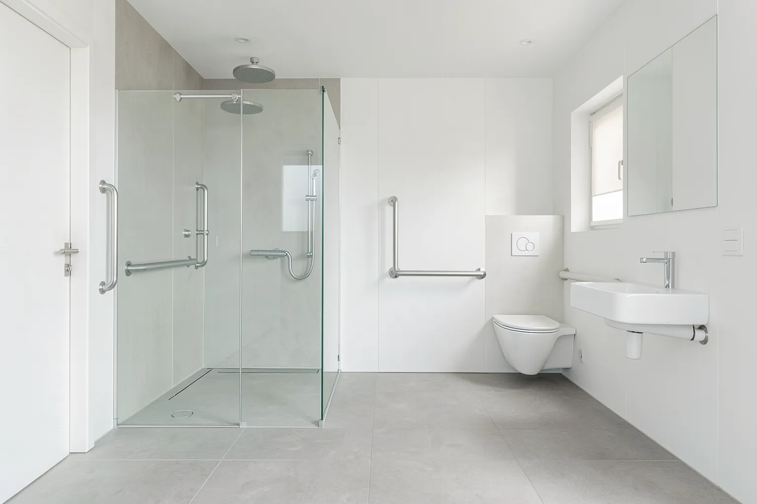Modernes barrierefreies Badezimmer mit bodengleicher Dusche, Haltegriffen und unterfahrbarem Waschtisch